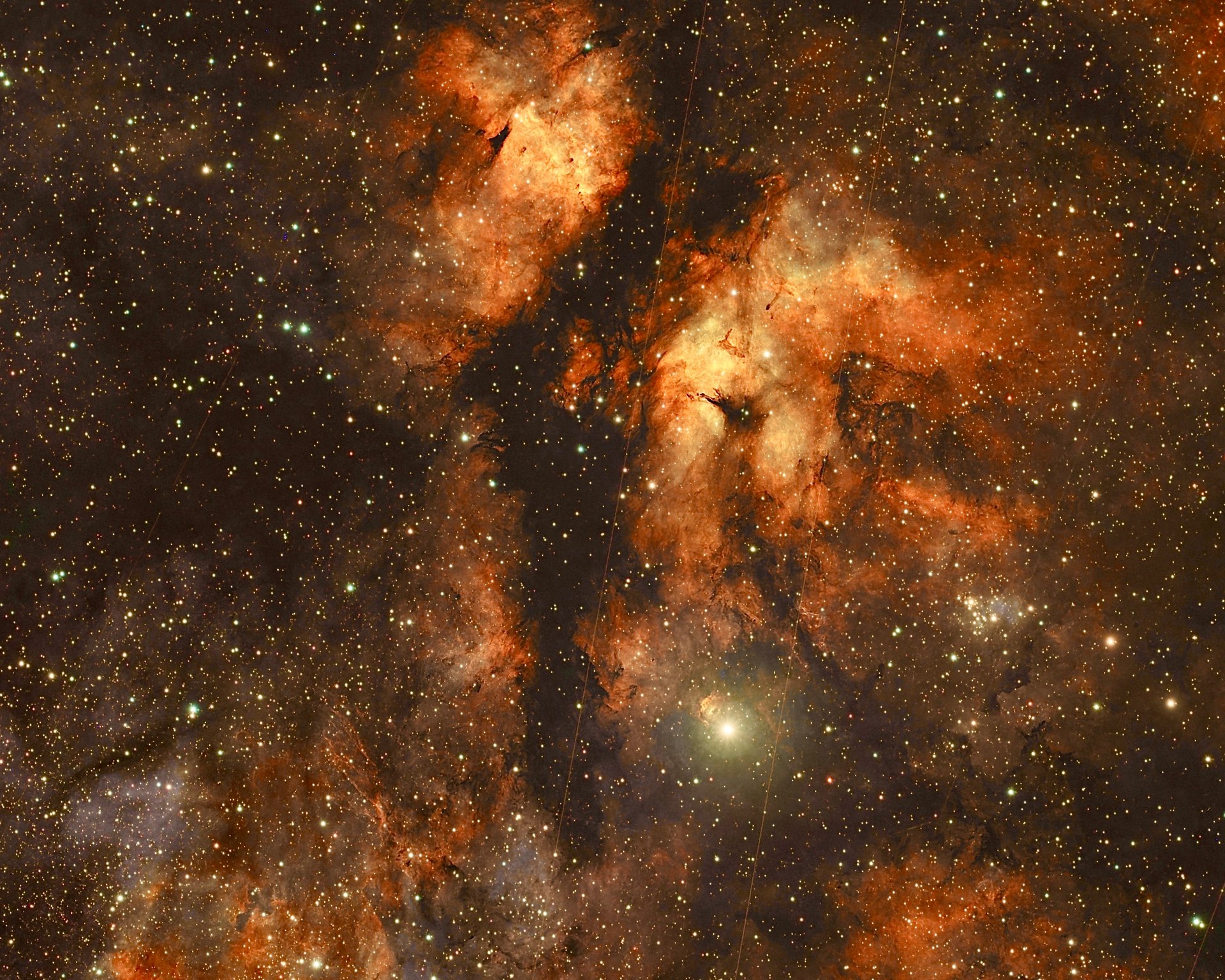 Wide-field astrophotography showing the Gamma Cygni Nebula (IC 1318), the bright star Sadr (Gamma Cygni), and the Dark Dahr Lane LDN 889 surrounded by dense glowing hydrogen emission clouds.