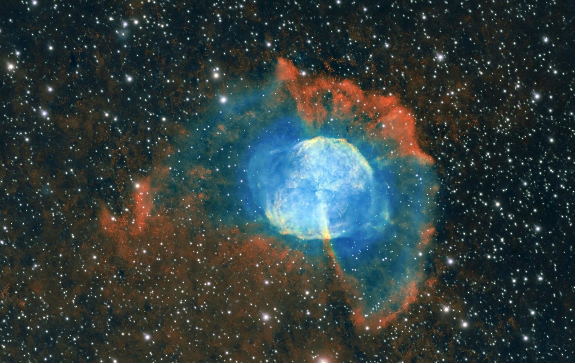 Deep-sky astrophotograph of M27, the Dumbbell Nebula (NGC 6853), showing its bright blue-green oxygen-rich interior, red hydrogen emission, extended outer shell and dense star field in Vulpecula.