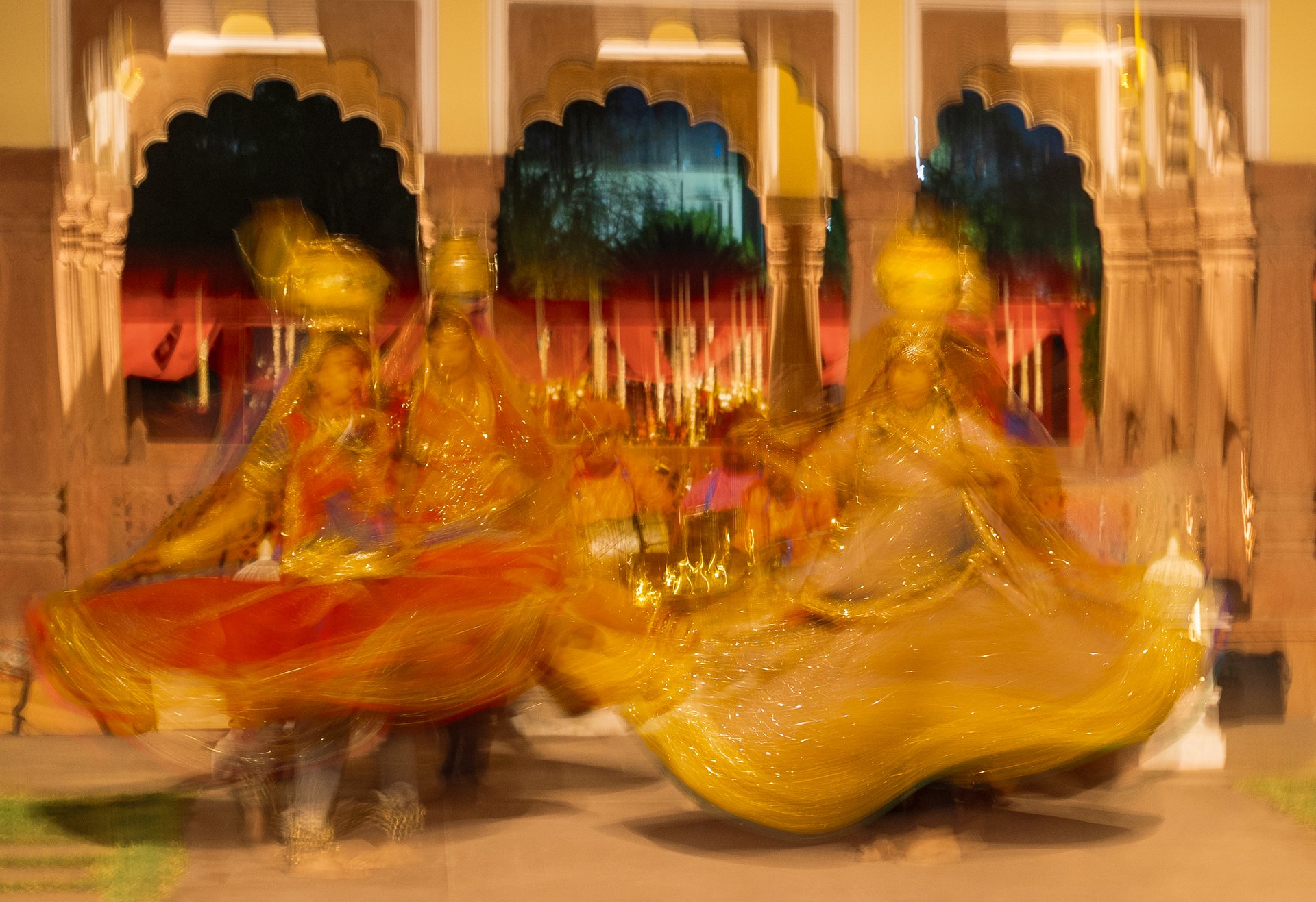 Colorful dancers in traditional attire performing a vibrant dance at night.